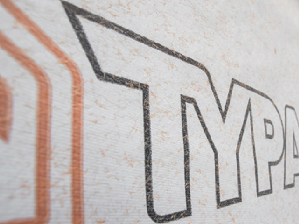 Figure 1: Randomly Oriented Orange Polypropylene Fibers on TYPAR® DrainableWrap and TYPAR® DrainableWrap Commercial